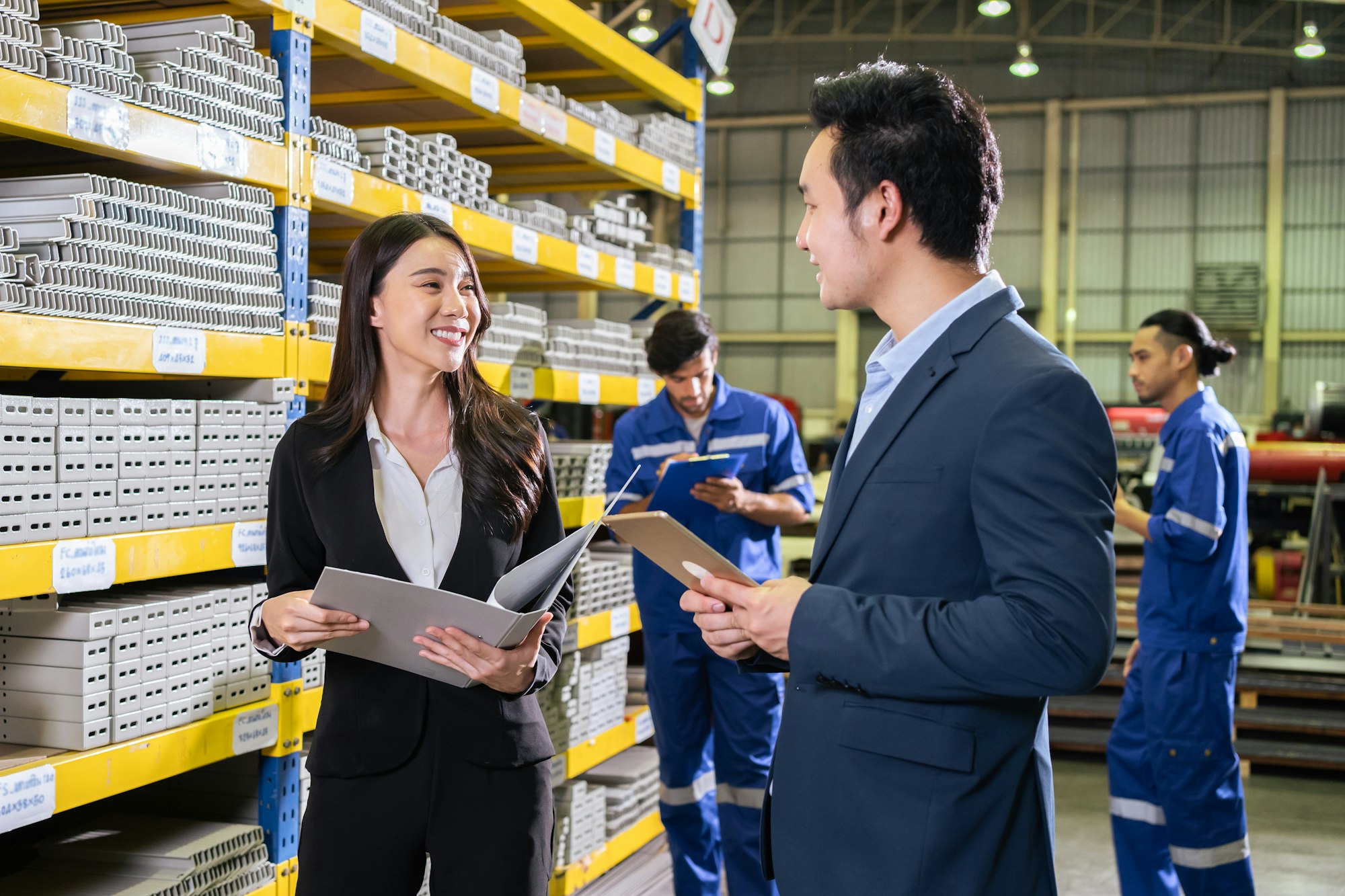 Asian business woman work in industry manufacturing plant with partner.